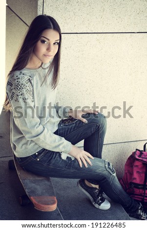 Beautiful teen girl with skateboard. Urban outdoors, teenager's lifestyle. Toned.