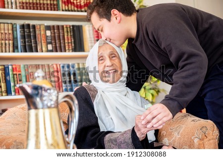 Arabic family enjoy eid celebration with grandmother while laughing together Royalty-Free Stock Photo #1912308088