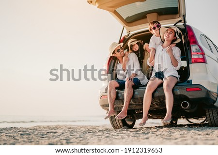 Happy family on a road trip in their car. Dad, mom and daughter are traveling by the sea. Summer ride by automobile. Royalty-Free Stock Photo #1912319653