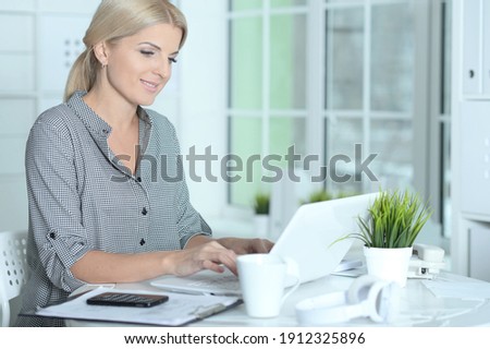 Portrait of beautiful smiling businesswoman working with laptop at home