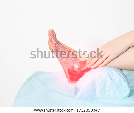 A man holds on to a sore ankle joint, pain in the foot and heel. Ligamentous apparatus diseases concept, ligament rupture. Anatomical Royalty-Free Stock Photo #1912350349