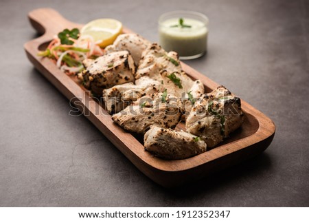 Indian Afghani chicken Malai Tikka is a grilled Murgh creamy kabab served with fresh salad Royalty-Free Stock Photo #1912352347