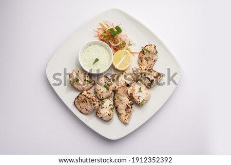 Indian Afghani chicken Malai Tikka is a grilled Murgh creamy kabab served with fresh salad Royalty-Free Stock Photo #1912352392