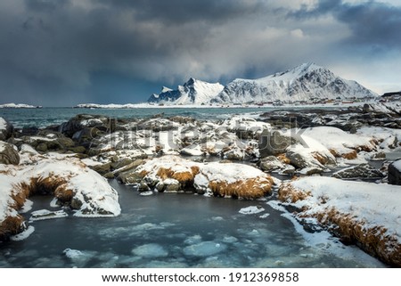 View of Lofoten islands, Norway. Panoramic landscape of winter mountains, dramatic sky and sea. Long exposure photography.  Winter landscape at the morning time. Norway, Europe