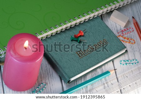 Layout composition with loose-leaf notebook on white wooden background with candle