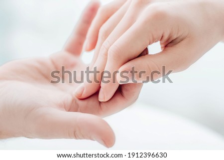Two hands gently touching each other closeup. Holding hands. Love, skin care, tenderness, relationship, Valentine's day, hands cream, softness, tenderness concept. Royalty-Free Stock Photo #1912396630