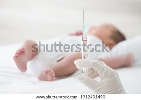 Syringe with blur baby background. Vaccine antivirus for infant 
concept Royalty-Free Stock Photo #1912401490