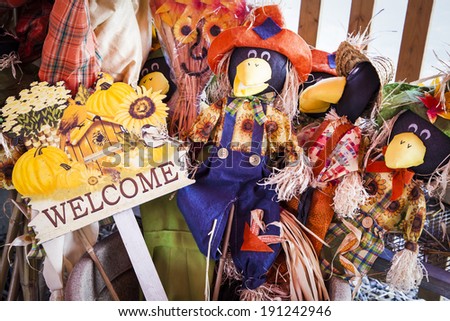 An assortment of Halloween and Thanksgiving decorations including scarecrow crows and welcome signs