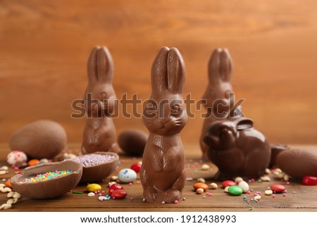 Chocolate Easter bunnies, candies and eggs on wooden table