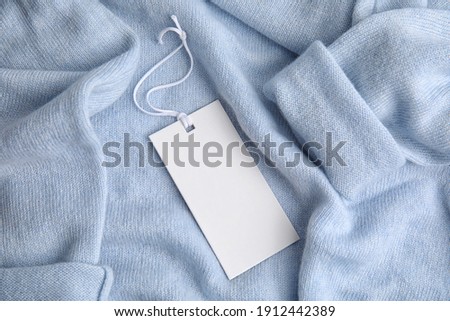 Warm light blue cashmere sweater with tag, closeup