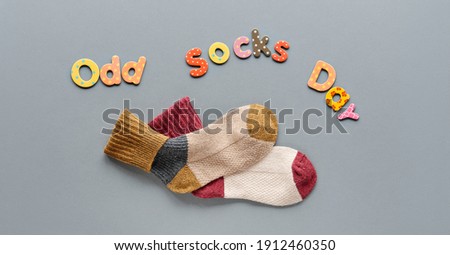 Odd Socks Day text. Pair of mismatched school socks. Social initiative against bullying in school or workplace. Promotion design for anti-bullying campaign.