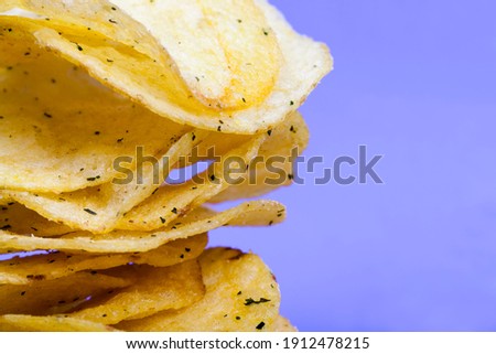 thin potato chips, crispy chips made from potatoes and deep fried, potato chips with salt and spices added to enhance the taste, closeup