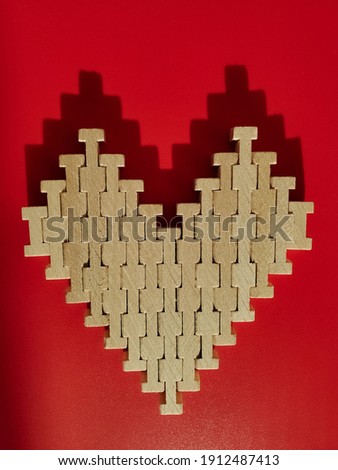 Wooden puzzle heart on a red background