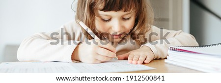 Cute preschooler girl writing maths, learning home. Education and distance learning for kids. Homeschooling concept. photo banner for website header design