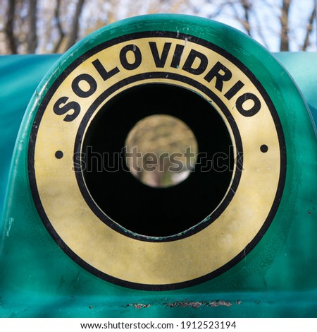 Detail view of a waste glass container for recycling. The translation of the Spanish text is "GLASS ONLY".