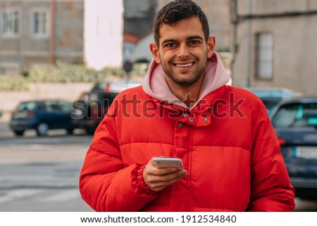 young man with mobile phone on the city street