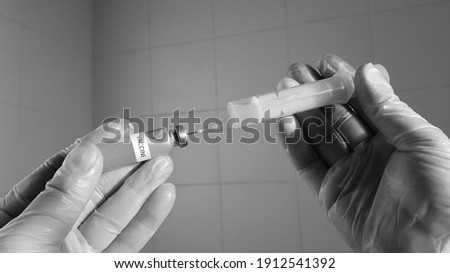 the doctor is holding a syringe and a coronavirus vaccine. vaccination of the population. the doctor's hands in vinyl gloves hold a vaccine and a syringe against diseases,