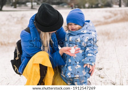 Mom and little daughter making snowball