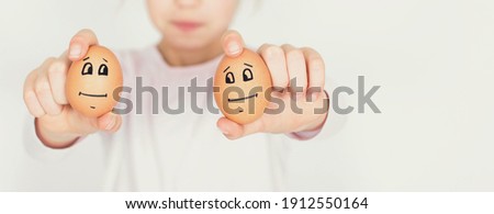 Young girl show two eggs with sad face isolated on white background. Easter and social distance concept.