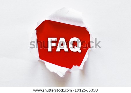 White torn paper with a word FAQ - Frequently Asked Questions.