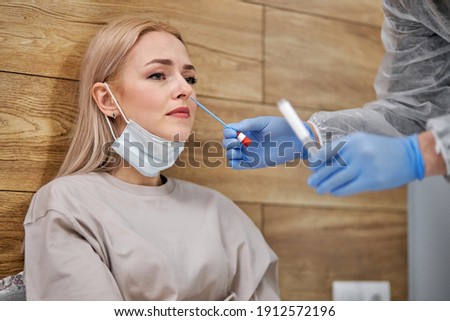 doctor visiting unhealthy sick woman at home, doing coronavirus covid-19 tests. experienced doctor in suit consults patient sitting on bed. patient care. diagnostics.