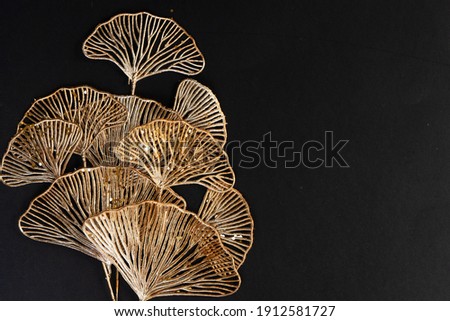 Golden tropical flowers on black background, top view with copy space