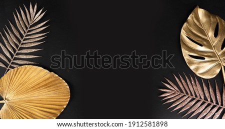 Golden tropical leaves on black background with copy space, 20s art deco style, web banner format