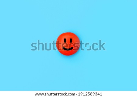 One red smile on a blue background. A funny smiley face on a candy bar. Top view