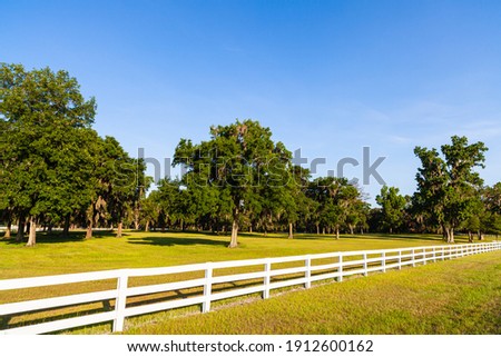 Beautiful white picket fence country ranch landscape. Royalty-Free Stock Photo #1912600162