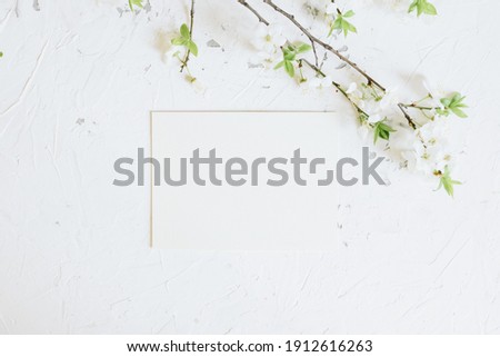 Romantic spring mock up with white card and blooming branches