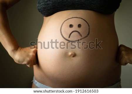 Sad angry pregnant woman. Weight gain and bad mood.