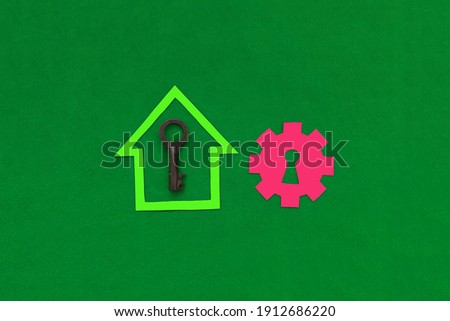 The house is green, the gear with the keyhole is red, the key is on a green background. The real estate market. Housing for sale.