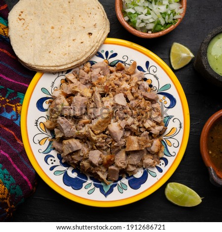 Confit pork called carnitas on dark background. Traditional mexican food