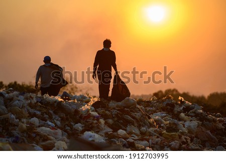 Poor people collect garbage for sale People living in garbage heaps walking to collect recyclable waste to be sold to poverty concept world environment day Royalty-Free Stock Photo #1912703995