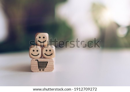 Smile face and cart icon on wooden cube. Optimistic person or people feeling inside and service rating when shopping, satisfaction concept in business.