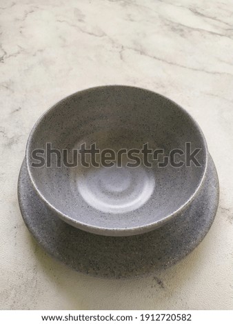 Plate and bowl melamine pottery model in stone gray color. Modern interior design. 