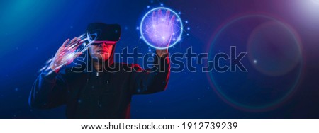 Asian man using VR glasses touching Technology Circles on blue technology background. Concept modern technologies and technologies of the future.
