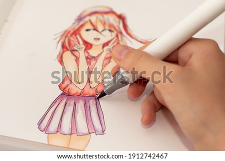 Selective focus image. Hand drawing a cute girl anime style sketch with alcohol based sketch drawing markers.