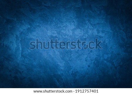 Blue decorative plaster texture with vignette. Abstract grunge background with copy space for design. Royalty-Free Stock Photo #1912757401