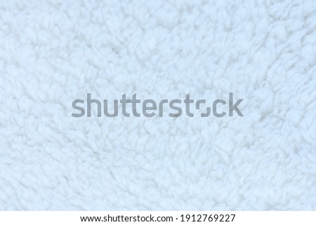 Background picture of a soft fur ิblue sky carpet. wool sheep fleece closeup texture background. Fake color beige fur fabric. top view.