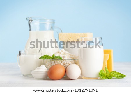 Various dairy products. Milk, cheese, cottage, sour cream. In front of blue background Royalty-Free Stock Photo #1912791091