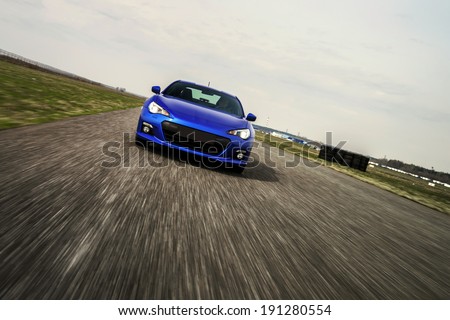Blue sport car on race way. Motion capture. Royalty-Free Stock Photo #191280554