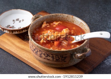 Tomato Soup with Chicken in a Cup on a Black Table