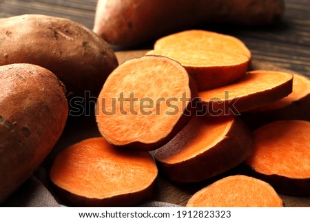 Composition of  fresh ripe sweet potatoes on wooden table background. Close-up.