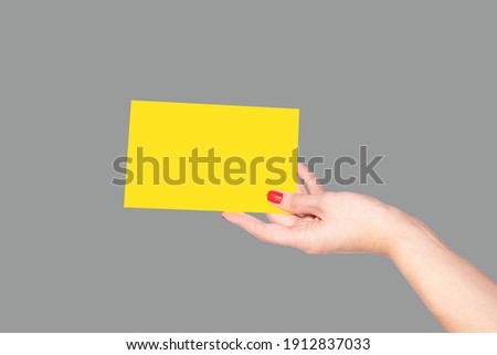 Female hand holds color of the year 2021 - Illuminating, yellow, mock up for text. On the Ultimate Gray background. A palette of color trends. Template for design. layout. copy space for text