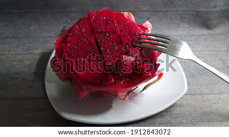 Ready to eat a red dragon fruit on white plate.exotic fruit from asia.Selenicereus undatus