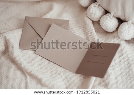 Invitation cards and an envelope on a fabric in a boho interior
