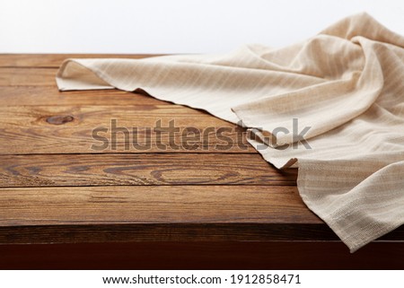 Empty white tablecloth on wooden desk perspective. Selective focus. Royalty-Free Stock Photo #1912858471