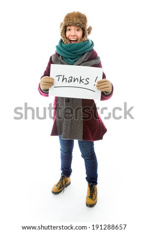Young woman in warm clothing and showing thanks sign on white background