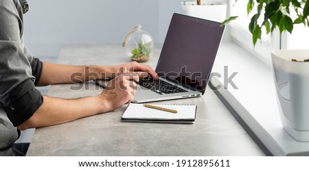Young happy designer working on laptop from home, freelance concept